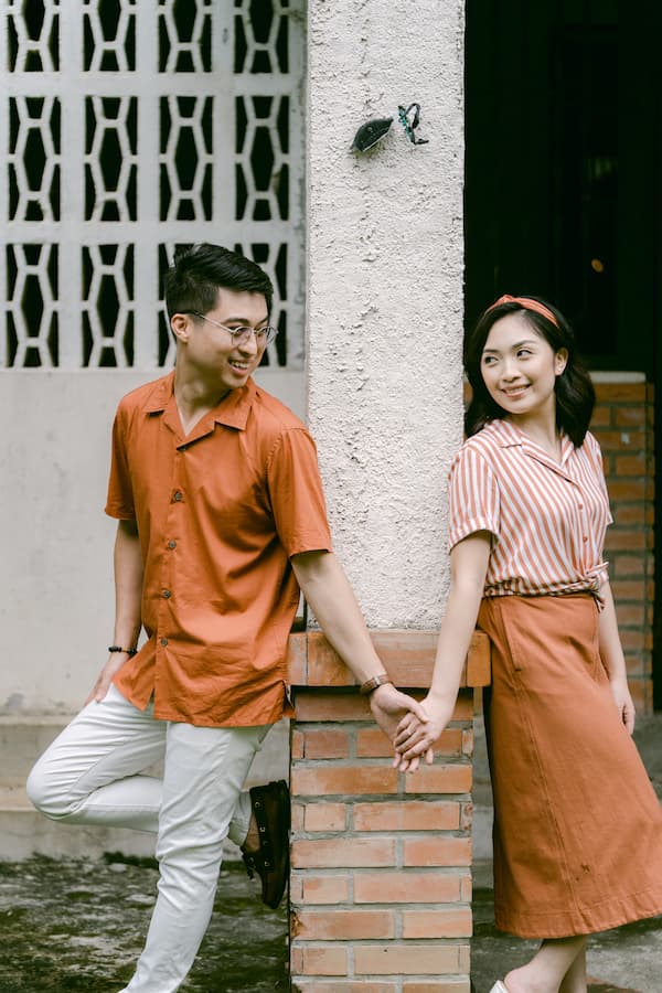 Asian couple in wedding attire at a traditional entrance